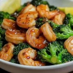 A sizzling Garlic Shrimp & Broccoli Stir-Fry in a wok, with shrimp, broccoli, and carrots coated in a flavorful garlic sauce, served fresh and steaming